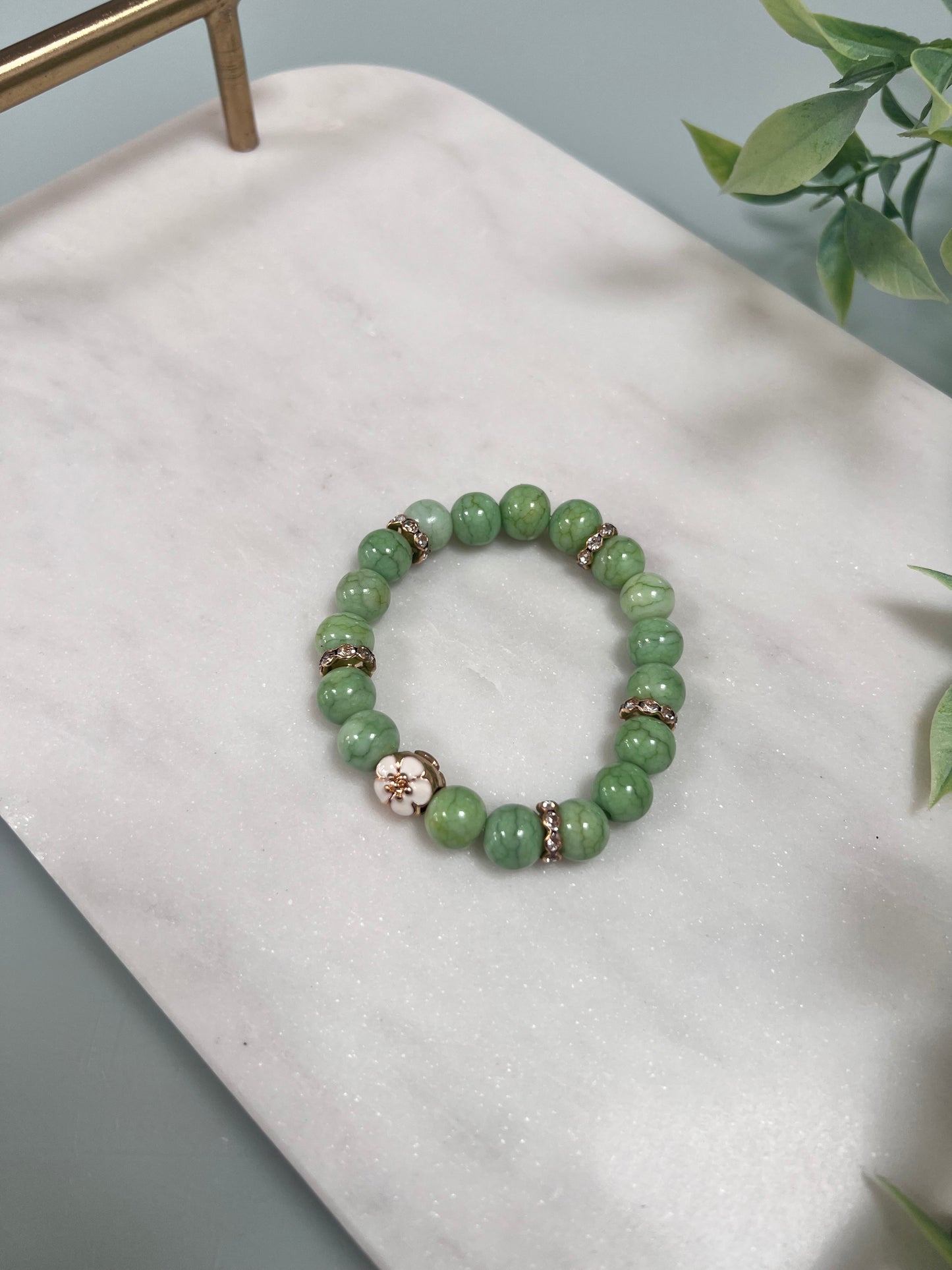 Green cracked glass beads & gold flower charm stretch bracelet
